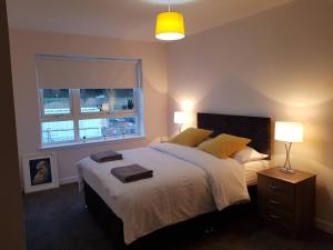een slaapkamer met een groot bed en 2 handdoeken bij 1 Royal View Apartments in Stirling