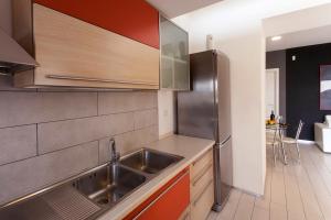 una cucina con lavandino e frigorifero in acciaio inossidabile di Villino Erminia - Seaside Art b&b a Pizzo
