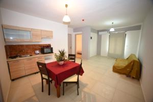 a kitchen and dining room with a red table and chairs at chalkiotis hotel in Anaxos