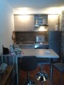 a kitchen with a table and two chairs and a refrigerator at margue residence meledrio in Folgarida