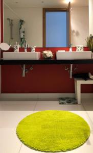 un bagno con due lavandini e un tappeto verde di View Apartament SAO JOAO a Funchal