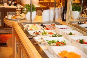 ein Buffet mit Speisen und Gläsern Wein in der Unterkunft Hotel Gletscherblick in Hippach