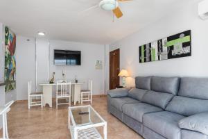 een woonkamer met een bank en een tafel bij Apartamento al lado de la playa in Benalmádena