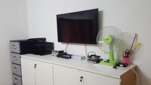 a television on top of a dresser with a fan at MYHome@Langkawi in Pantai Cenang