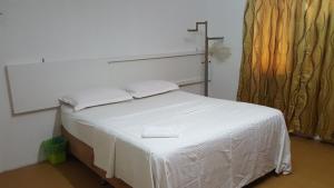 a white bed in a room with a window at MYHome@Langkawi in Pantai Cenang