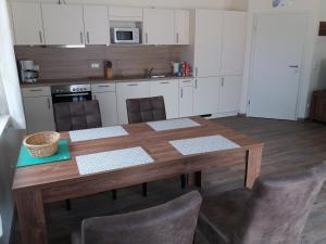 a kitchen with a wooden table and chairs in it at Störti 11 in Gnies