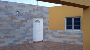 a white door and a window on a brick wall at Finca Los Rosales in La Lajita