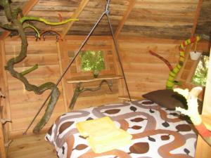 a cat laying on a bed in a log cabin at Une Nuit aux Lierres... in Vouzon