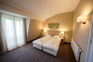 a hotel room with a bed and a window at Fletcher Hotel Het Veluwse Bos in Beekbergen