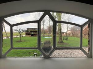 an open window with a view of a yard at B&NB The Barnhouse in Bergambacht