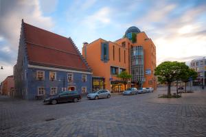 een stadsstraat met auto's geparkeerd voor gebouwen bij Hotel Theresientor in Straubing
