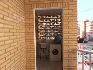 łazienka z pralką i ceglaną ścianą w obiekcie Apartamentos Mary w mieście Fuengirola