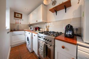 a kitchen with white cabinets and a stove top oven at Harrogate 100 in Harrogate