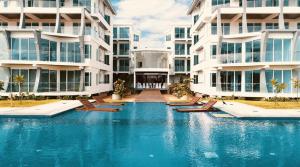 a swimming pool in front of some apartment buildings at 123 Ocean Front Condo in Nilaveli
