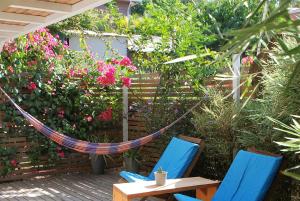a hammock in a garden with flowers and plants at Casa SILURI in Santa Teresa Beach