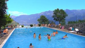 a group of people in a swimming pool at Hotel Garnì Al Poggio in Tignale