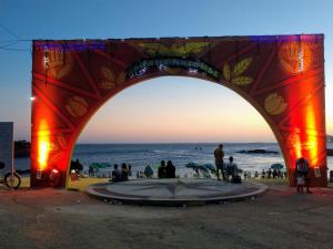 a group of people sitting under an arch over the ocean at Flat Pasárgada 812 - vista para a Praia da Costa, academia moderna, piscinas panorâmicas, minimercado e lavanderia in Vila Velha