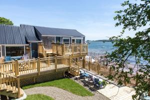 a house with a large deck next to the water at Seaside Beach Resort in Saint Andrews