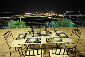 a table with chairs sitting on a balcony at night at Villas Panorama Apolpaina Lefkas in Apolpaina