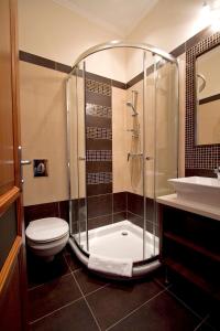 a bathroom with a shower and a toilet and a sink at Centrum Panzió in Mohács