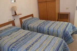 ラポラーノ・テルメにあるCasetta delle Termeのベッドルーム1室(隣り合わせのベッド2台付)