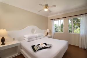a white bedroom with a white bed and a window at Lifestyle Crown Residence Suites in San Felipe de Puerto Plata