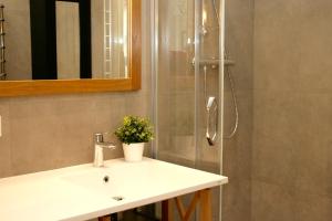 y baño con lavabo y ducha. en Elegant apartment, en Liepāja