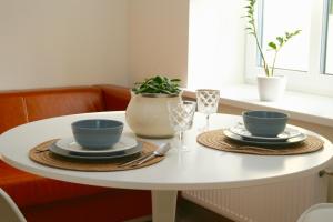 a white table with two cups and plates on it at Elegant apartment in Liepāja