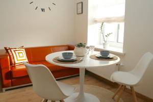 una mesa blanca y sillas en una habitación con sofá en Elegant apartment, en Liepāja