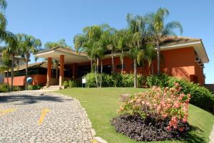 a house with a garden in front of it at Apartamento no Porto Real Resort com vista para o mar in Mangaratiba
