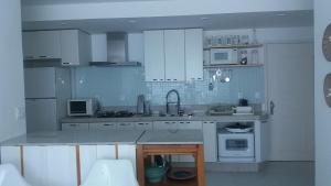 a kitchen with white cabinets and a gray counter top at Apartamento no Porto Real Resort com vista para o mar in Mangaratiba