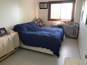 a bedroom with a bed with a blue blanket on it at Apartamento no Porto Real Resort com vista para o mar in Mangaratiba +20 photos