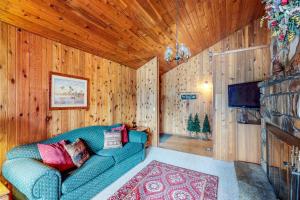 a living room with a blue couch and a television at Ponderosa Cabin in Cascade