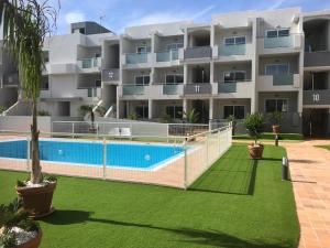 kompleks apartamentów z basenem przed budynkiem w obiekcie Nice and sunny apartment w Corralejo