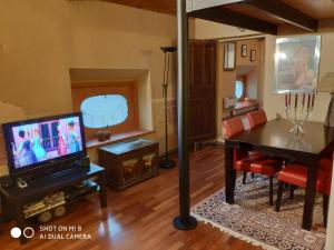 a living room with a television and a dining table at Il Castello delle Fiabe in Scandeluzza