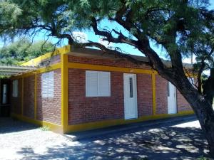 una casa de ladrillo rojo con un adorno amarillo en La bendicion en Villa Cura Brochero