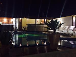 a swimming pool with chairs and a potted plant at Pousada Requinte da Mantiqueira in Piracaia