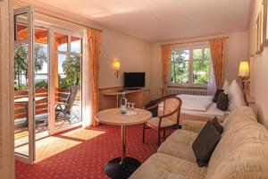 a hotel room with a couch and a bed and a table at Aparthotel Am See in Plau am See