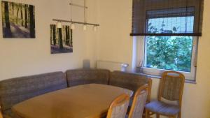 sala de estar con sofá, mesa y sillas en Haus Zwanzig, en Weisel