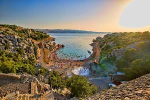 a group of people in the water at a beach at Apartments Marija Karlobag in Karlobag