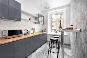a kitchen with gray cabinets and a counter with a microwave at WOW Hostel in Moscow