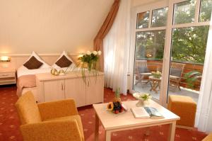 a bedroom with a bed and a table and chairs at Aparthotel Am See in Plau am See