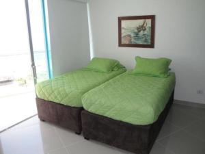 two twin beds in a bedroom with a picture on the wall at Apartamento Cartagena Alquiler - Edif Seaway 935 in Cartagena de Indias +23 photos