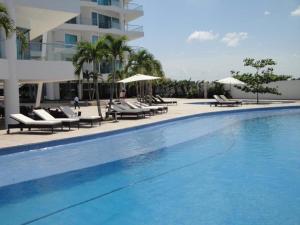 a large swimming pool with lounge chairs and a building at Apartamento Cartagena Alquiler - Edif Seaway 935 in Cartagena de Indias
