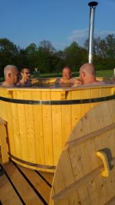 Domki całoroczne Bieszczady Panasiewiczówka في Odrzechowa: مجموعة من الرجال في حوض استحمام ساخن