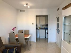 kuchnia i jadalnia ze stołem i krzesłami w obiekcie Clubrent - Apartamentos Apolo 17 w mieście Calpe