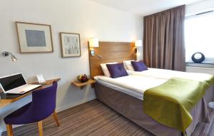 a hotel room with a bed and a desk and a laptop at Hotell Högland in Nässjö +21 photos