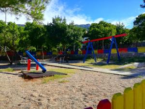 a playground with blue and red swings at Apartments Marija Karlobag in Karlobag