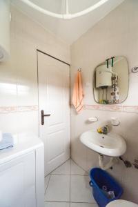 Danube Villa Tamaris في سميديريفو: حمام أبيض مع حوض ومرآة