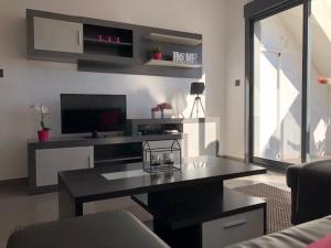 a living room with a table and a television at Penthouse 86 LA ZENIA boulevard in Orihuela